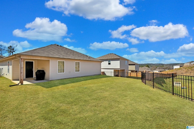 back of house featuring a fenced backyard, a yard, and a patio