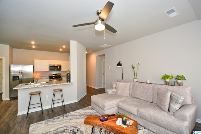 living area with baseboards, visible vents, a ceiling fan, dark wood-style flooring, and recessed lighting