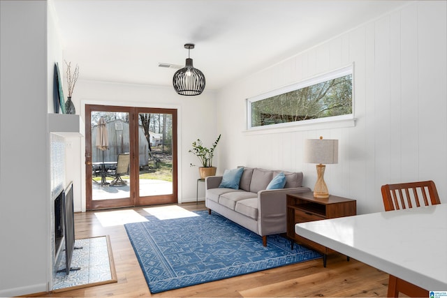 interior space with a fireplace with flush hearth, visible vents, and wood finished floors