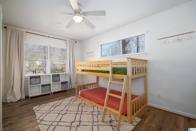 bedroom with wood finished floors, a ceiling fan, and baseboards