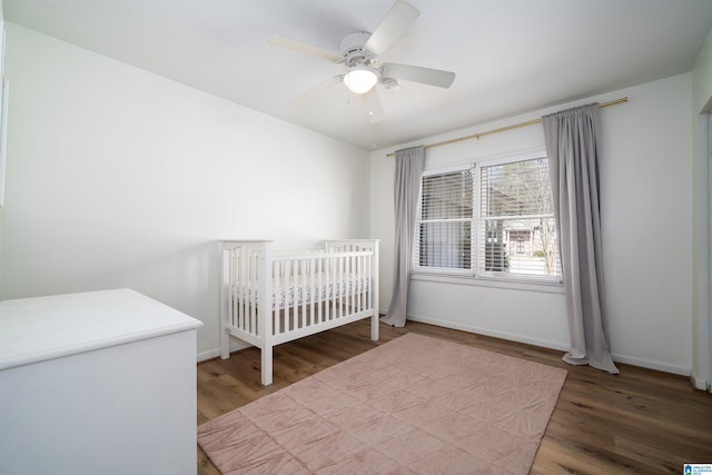 unfurnished bedroom with ceiling fan, baseboards, and wood finished floors