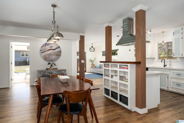 dining space with ornate columns and dark wood finished floors