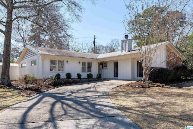 ranch-style home with driveway and a chimney