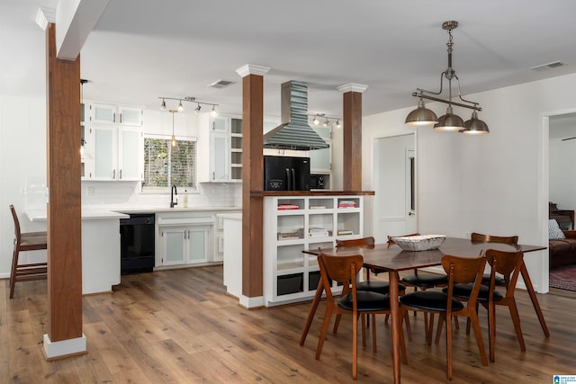 dining space with visible vents, ornate columns, and wood finished floors