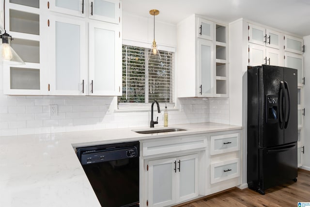 kitchen with black appliances, tasteful backsplash, white cabinets, and a sink