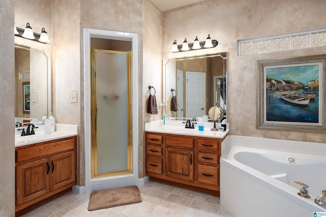 bathroom with a garden tub, two vanities, a stall shower, and a sink