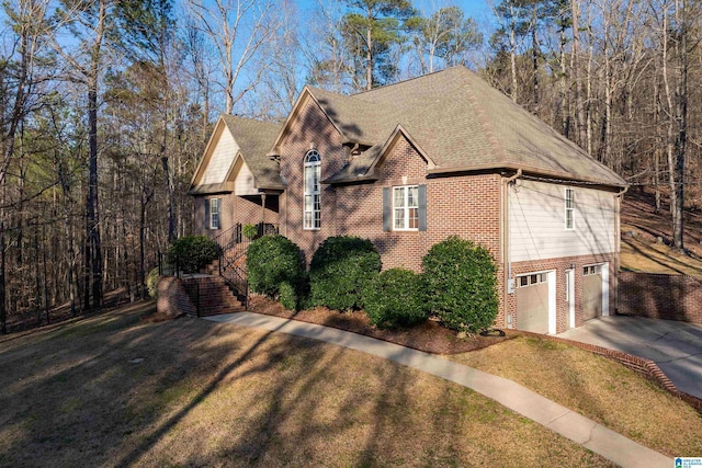 view of front of house featuring roof with shingles, a front lawn, concrete driveway, a garage, and brick siding