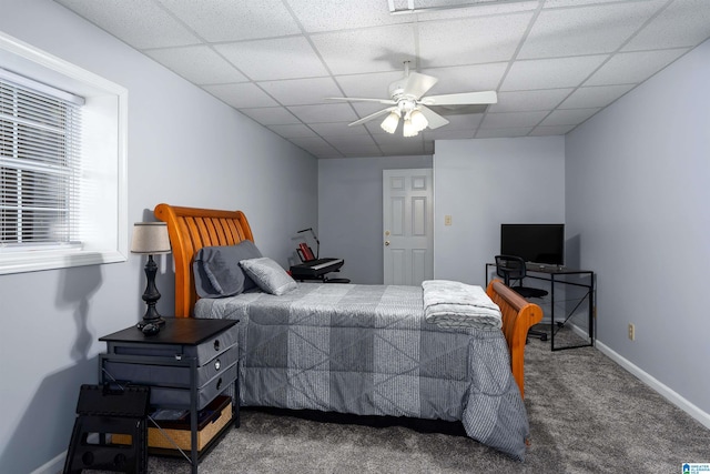 bedroom with a drop ceiling, a ceiling fan, baseboards, and carpet floors