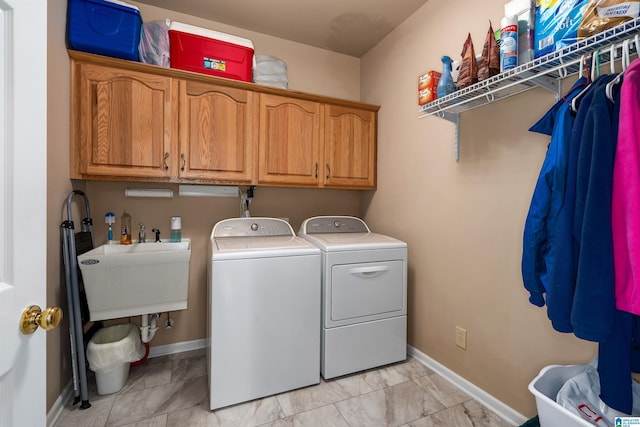 laundry room featuring washer and clothes dryer, cabinet space, and baseboards