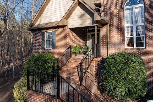 property entrance with brick siding and roof with shingles