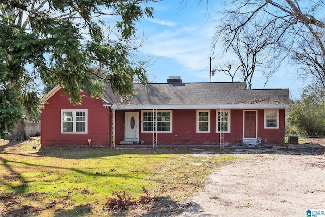 ranch-style house with a front yard, cooling unit, and a chimney