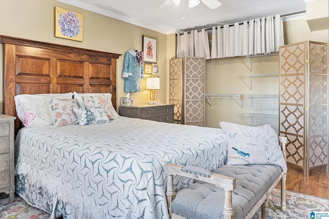 bedroom featuring ceiling fan, crown molding, and wood finished floors