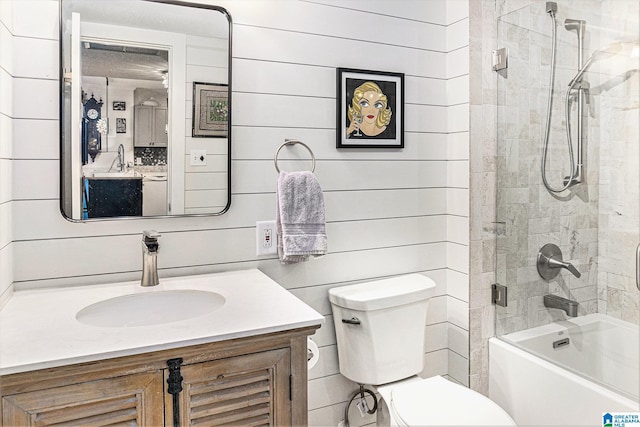 full bath with  shower combination, wooden walls, vanity, and toilet