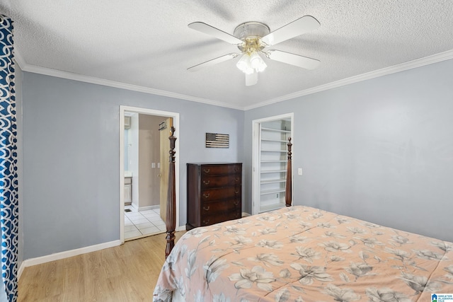 bedroom featuring a textured ceiling, light wood-style flooring, and crown molding