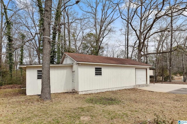 view of side of home with an outdoor structure and driveway