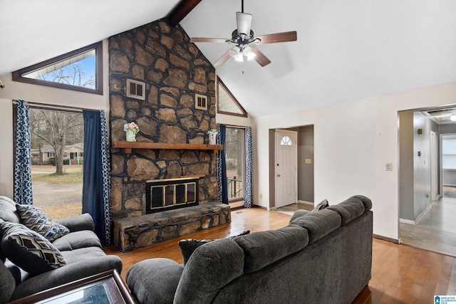 living room with baseboards, a ceiling fan, wood finished floors, beamed ceiling, and a fireplace