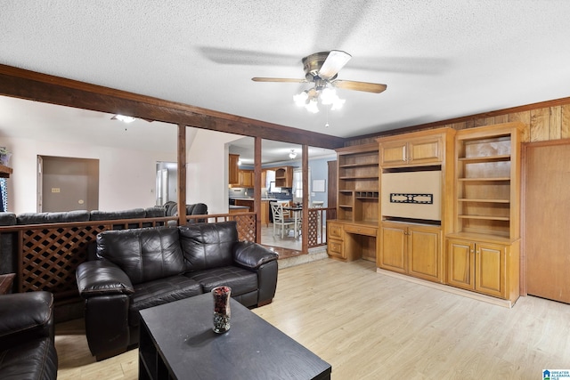 living area featuring light wood-type flooring, a textured ceiling, and built in study area