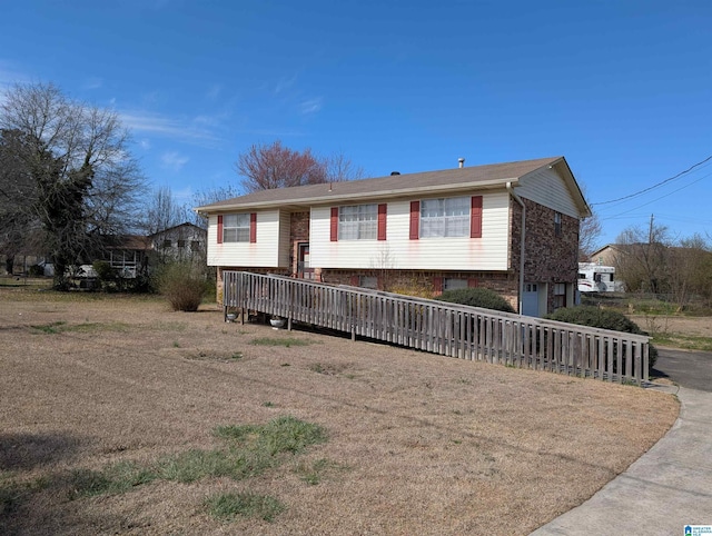 split foyer home featuring a garage, brick siding, and driveway