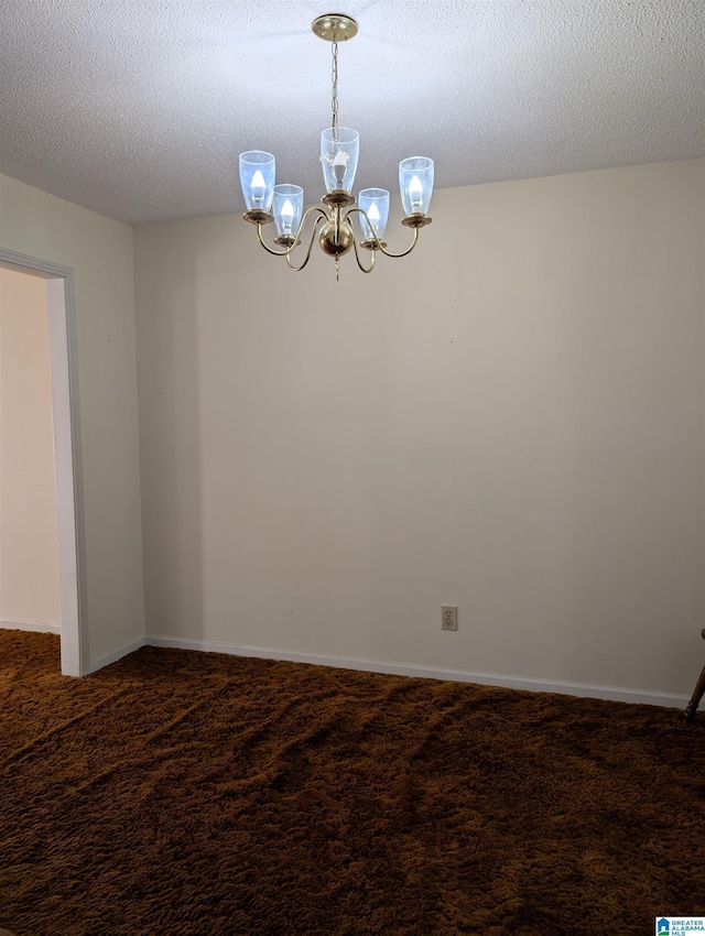 empty room featuring a textured ceiling, baseboards, carpet flooring, and a notable chandelier