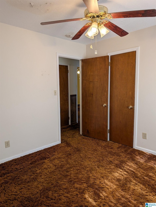 unfurnished bedroom featuring a ceiling fan, carpet flooring, a textured ceiling, and baseboards