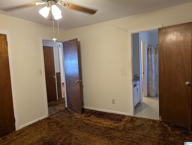 unfurnished bedroom with a textured ceiling, baseboards, and carpet flooring