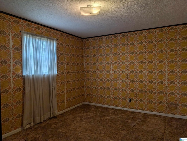 empty room with a textured ceiling, baseboards, carpet flooring, and wallpapered walls