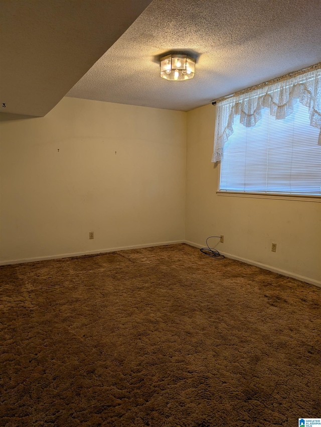 unfurnished room with baseboards, dark colored carpet, and a textured ceiling