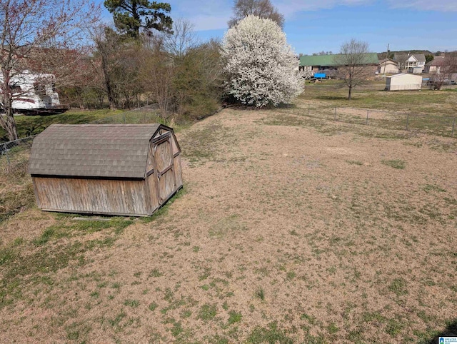 view of yard with an outbuilding, fence, and a shed