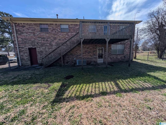 rear view of property with fence, stairway, and a yard