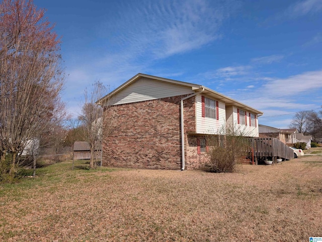 view of home's exterior featuring a yard and brick siding