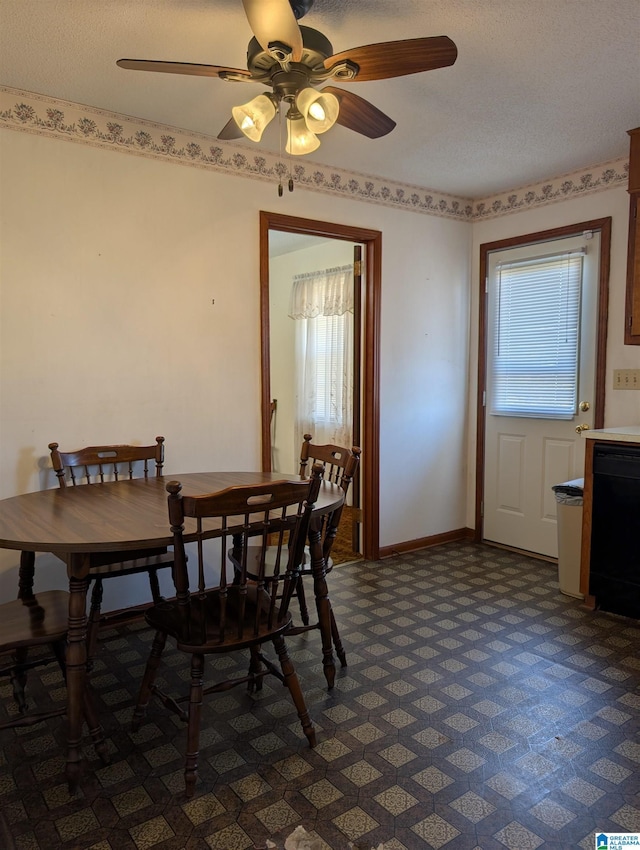 dining area with a textured ceiling, dark carpet, and baseboards