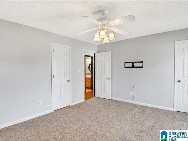 unfurnished bedroom with a ceiling fan, light carpet, a textured ceiling, and baseboards