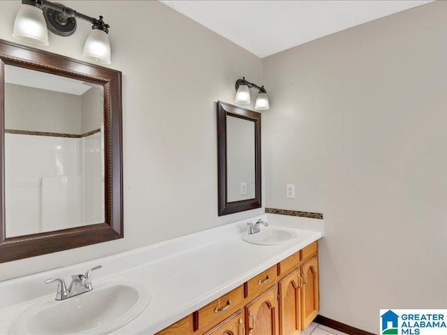 full bathroom featuring a sink, baseboards, and double vanity