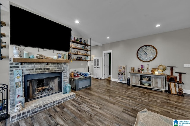 living room featuring a brick fireplace, baseboards, wood finished floors, and recessed lighting