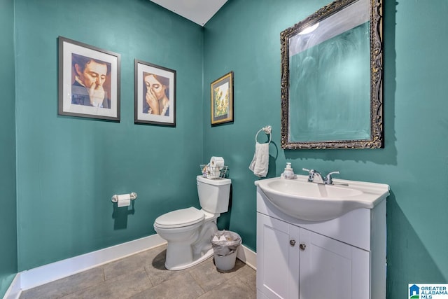 half bathroom featuring baseboards, vanity, and toilet