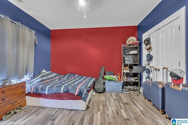 bedroom featuring a ceiling fan, a closet, and wood finished floors