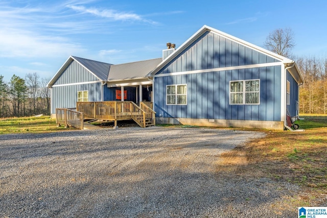 view of front of house featuring a chimney, metal roof, and board and batten siding