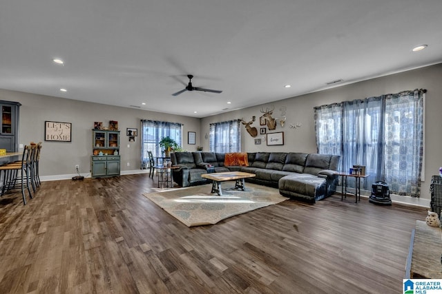 living room with baseboards, dark wood-style flooring, visible vents, and recessed lighting