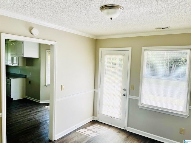 entryway featuring a textured ceiling, visible vents, dark wood-type flooring, and ornamental molding