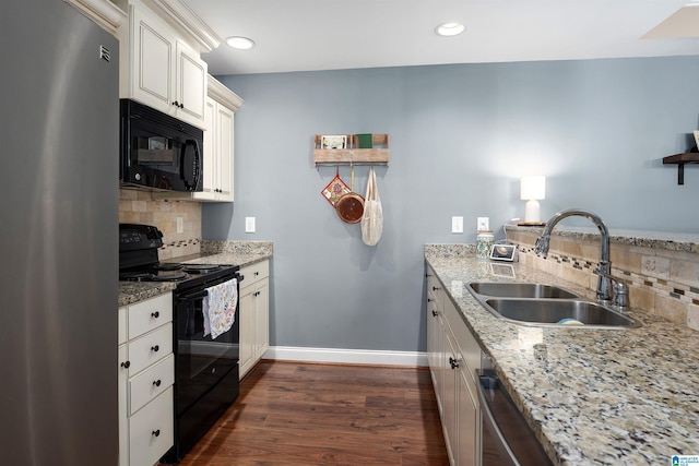 kitchen with tasteful backsplash, a sink, baseboards, black appliances, and dark wood-style flooring