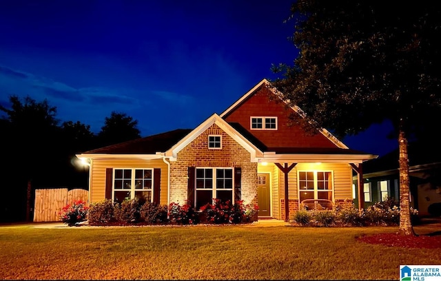 view of front of home featuring a lawn and fence