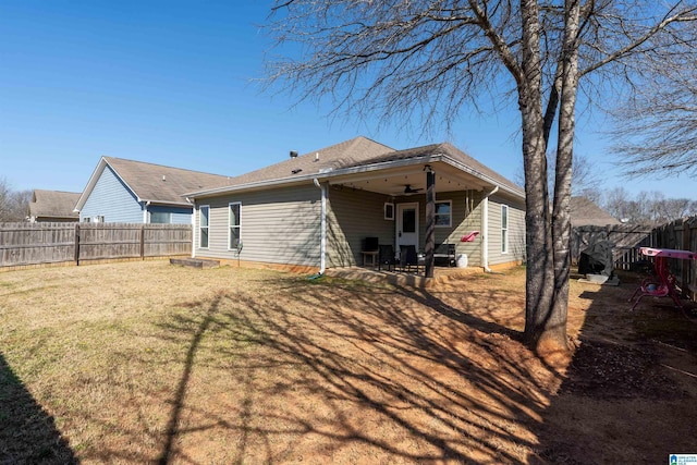 rear view of house with a patio area, a yard, a ceiling fan, and a fenced backyard