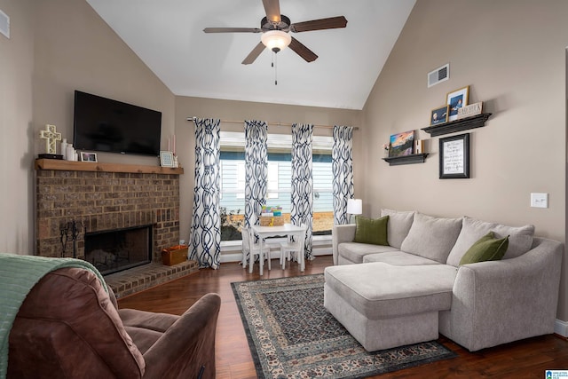 living area featuring visible vents, a fireplace, wood finished floors, and a ceiling fan