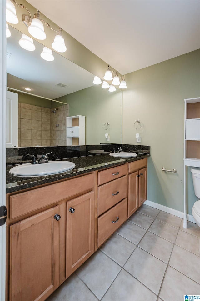 bathroom with toilet, visible vents, a sink, and tile patterned floors