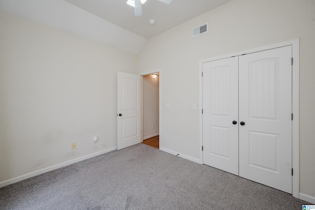 unfurnished bedroom featuring visible vents, baseboards, carpet, vaulted ceiling, and a closet