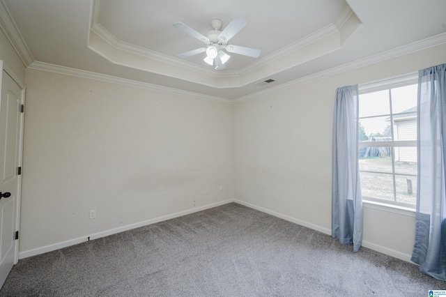 unfurnished room featuring a tray ceiling, carpet flooring, visible vents, and baseboards