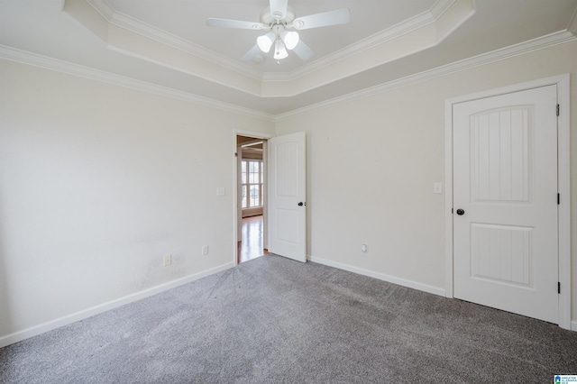 unfurnished room with baseboards, a tray ceiling, carpet flooring, and ornamental molding