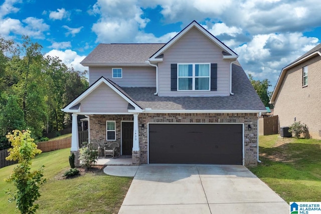 craftsman house with a front yard, concrete driveway, brick siding, and fence