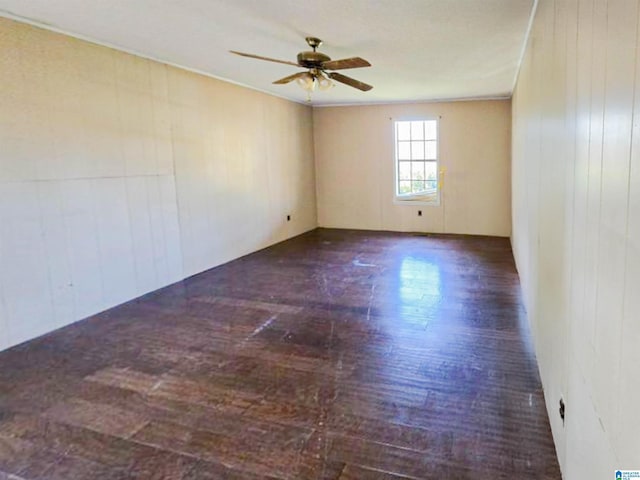 empty room with a ceiling fan and wood finished floors