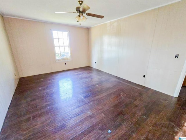 empty room featuring wood-type flooring, ceiling fan, and crown molding